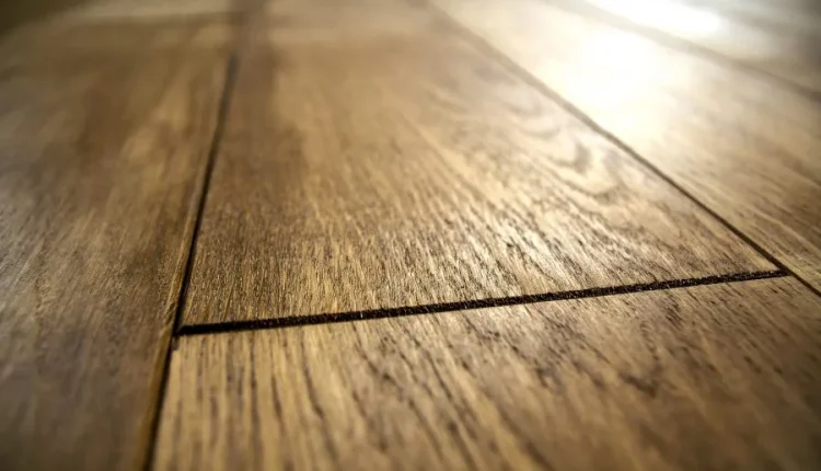 Close-up of warm-toned wooden floorboards with visible grain and seams.